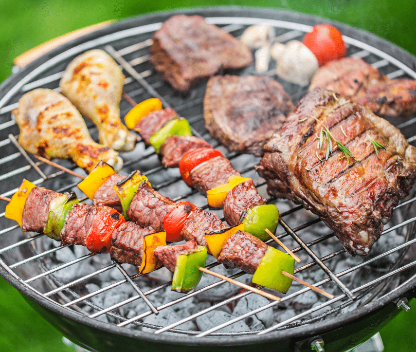 Barbecue in de tuin met vlees en groenten op het rooster tijdens een zomerse avon